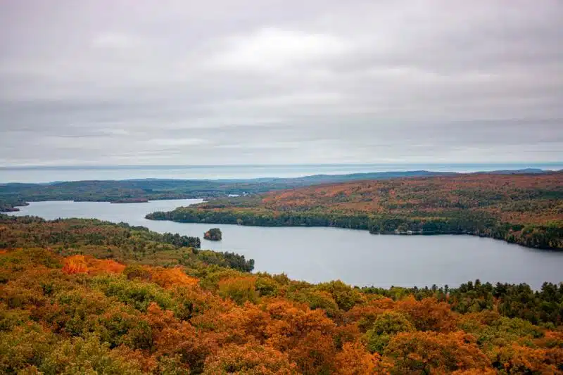 Autumn landscape of Nova Scotia with vibrant fall colors surrounding a serene lake, often found in parts of Nova Scotia's countryside