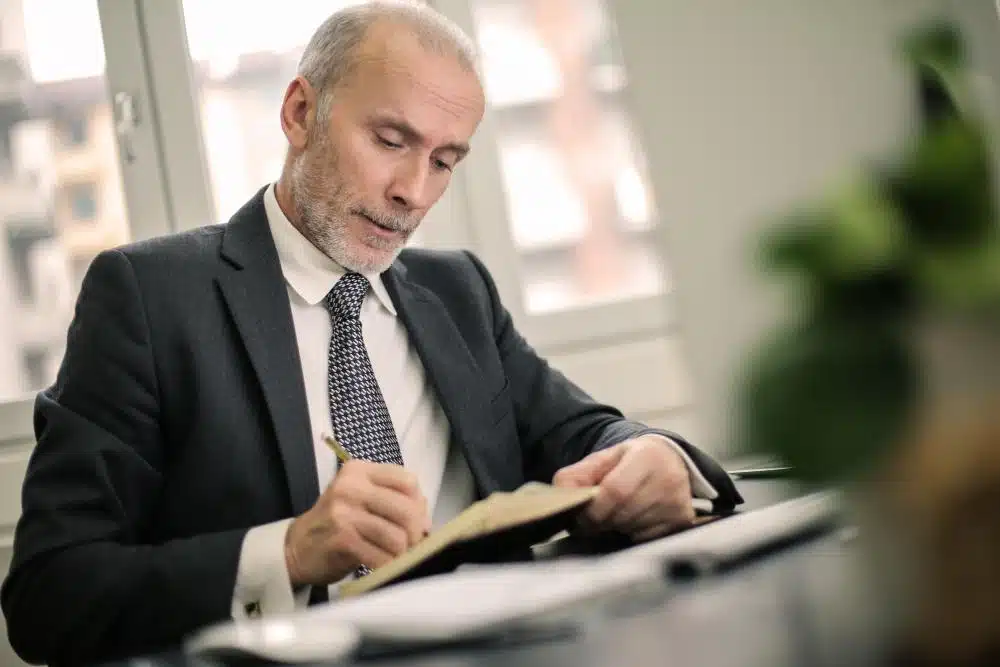 Professional man in a suit reviewing documents, symbolizing expertise and assistance in resolving CRA tax liens.