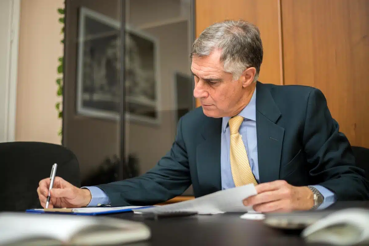 Senior Alabama tax lawyer reading tax documents in office