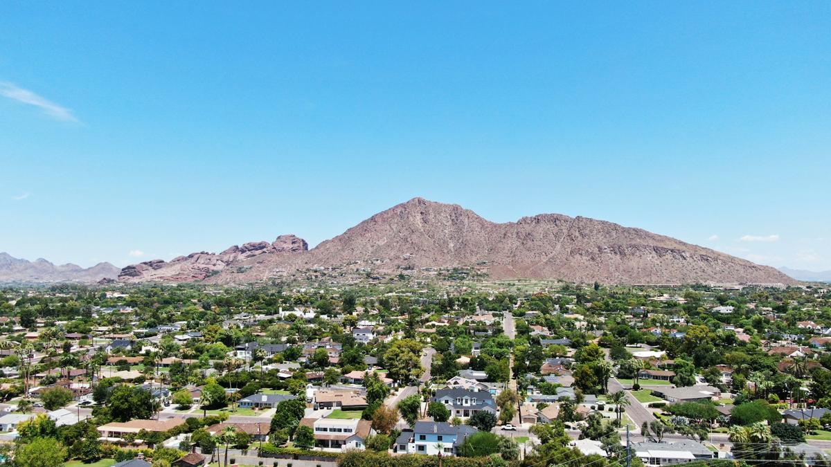 A scenic aerial view of Camelback Mountain in Arizona, overlooking residential neighborhoods under a clear blue sky.