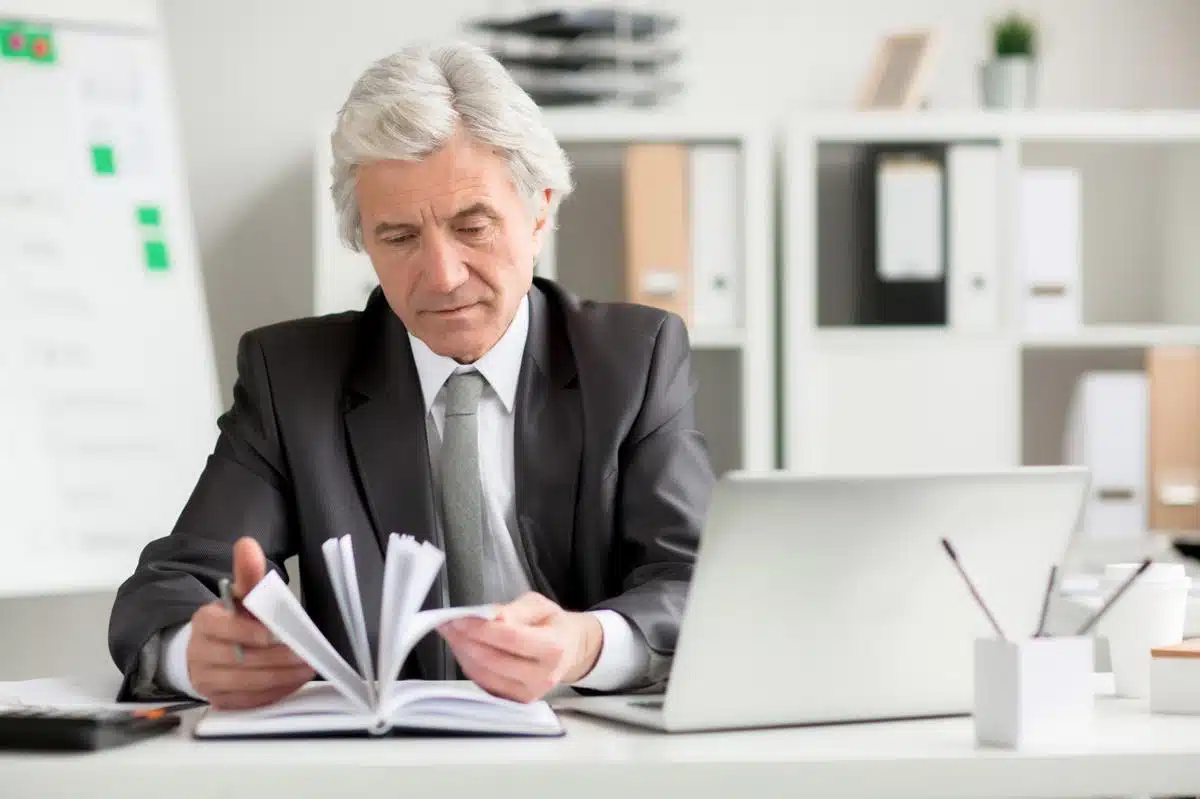 Experienced tax lawyer in Colorado reviewing legal documents at his office, providing expert tax resolution services.