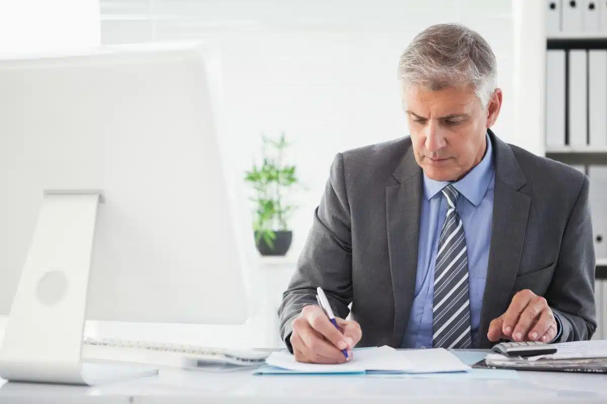 Experienced tax lawyer in Florida working on financial documents at his desk, providing expert legal tax assistance.