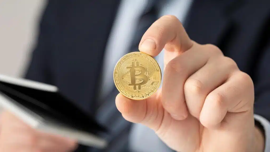 Person holding a Bitcoin coin, symbolizing cryptocurrency tax legal services.