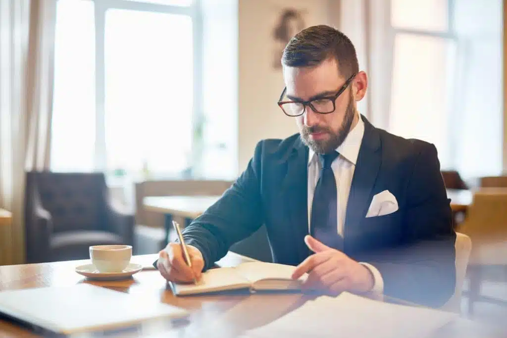 Professional tax attorney in Los Angeles writing notes during a legal planning session.