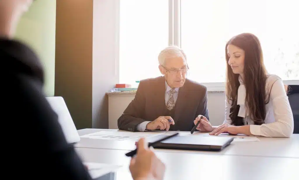 Experienced tax lawyer meeting with a client in a sunlit office, reviewing documents related to tax liens and offering legal advice.
