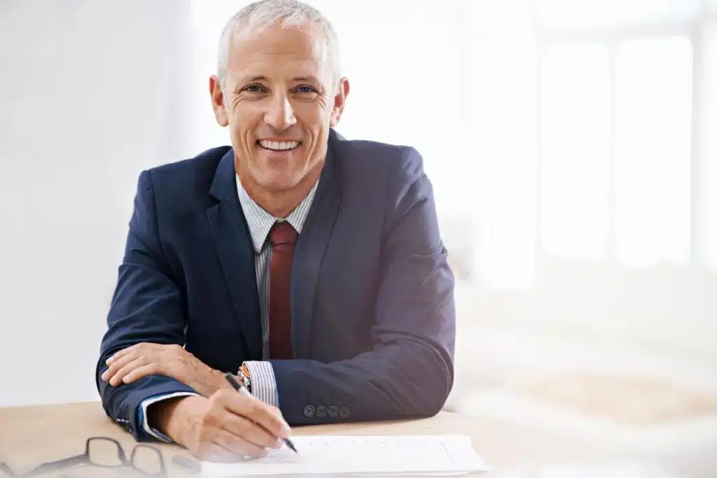 Smiling tax lawyer sitting at a desk in New Jersey office.