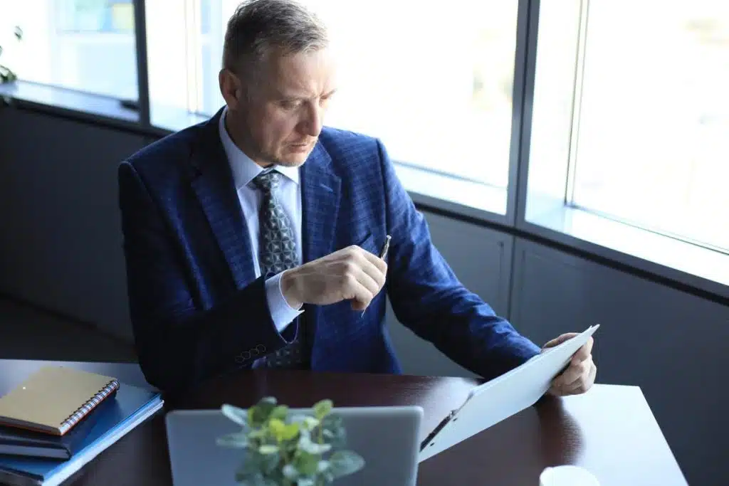 Professional tax lawyer reviewing legal documents at his desk in Sacramento office.